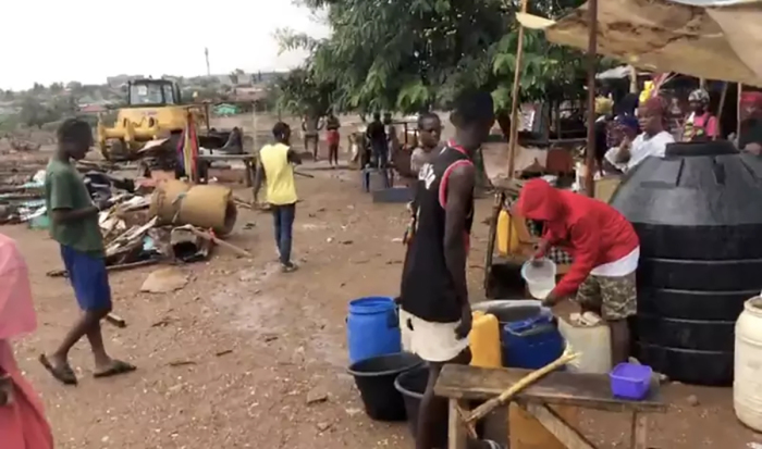 Alors qu'un bulldozer détruit les bâtiments, la population déplacée rassemble ses affaires mais n'a nulle part où aller, selon Dennis Yoko Gwion.