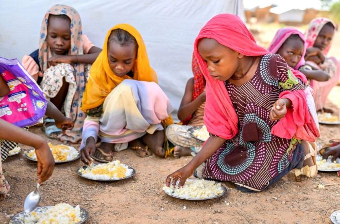 Des enfants au Soudan mangent de la nourriture fournie par World Vision.