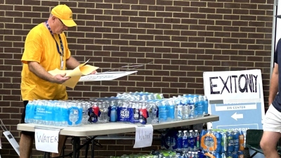 Un bénévole aide à distribuer de l'eau aux milliers de personnes qui se sont présentées pour obtenir des fournitures de base à la First Baptist Church Hendersonville à Hendersonville, en Caroline du Nord, le 30 septembre 2024.