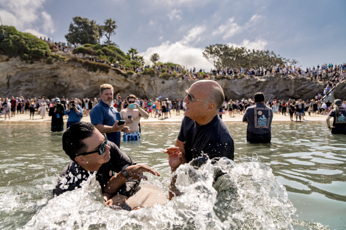 Greg Laurie aide à baptiser un participant d'un baptême de masse qui s'est tenu à Pirate's Cove Beach en Californie le 8 juillet 2023.