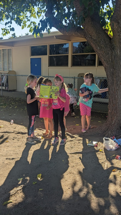 Lucie, une élève de première année de Californie, lit la Bible à ses camarades de classe alors qu'ils attendent d'être récupérés à l'école. 
