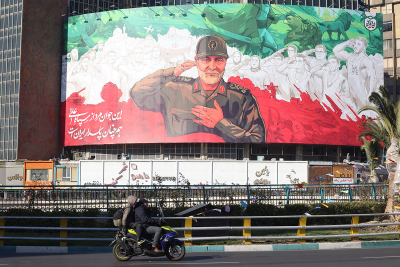 Les Iraniens roulent en moto devant une immense bannière de l'ancien commandant de la Force Qods du Corps des Gardiens de la révolution islamique iranien (CGRI), Qasem Soleimani, à l'approche du sixième anniversaire de son assassinat. Photo prise sur la place Valiasr à Téhéran, le 31 décembre 2025. Soleimani a été tué le 3 janvier 2020 lors d'une frappe aérienne américaine ciblée sur l'aéroport de Bagdad en Irak.